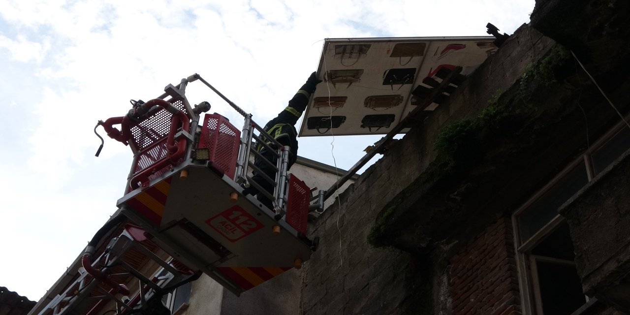 Çatıdan tehlikeli şekilde sarkan pano, itfaiye ekiplerince kaldırıldı