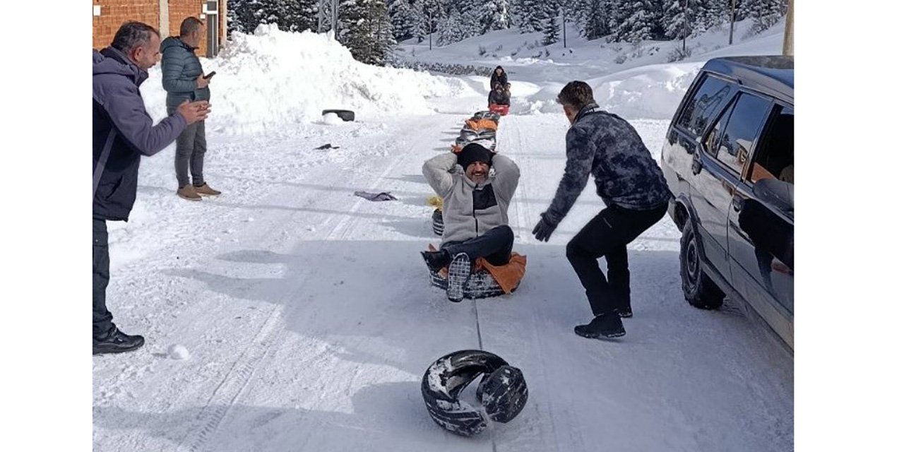 Kamyonete bağlanan ipe tutturulan şambrellerin üzerine oturup kaydılar