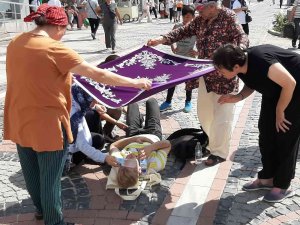 Kadınlar Yerde Yatan Yaralıyı Örtü İle Güneşten Korudu