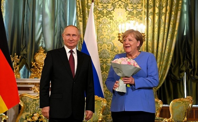 Putin, Merkel’le Görüşmesine Çiçekle Geldi