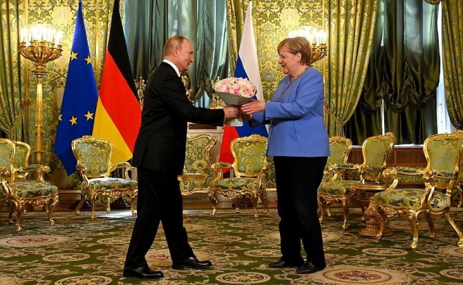 Putin, Merkel’le Görüşmesine Çiçekle Geldi